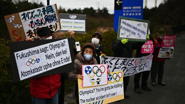 Manifestantes cerca de J-Village en Japón, donde comenzará el relevo de la antorcha