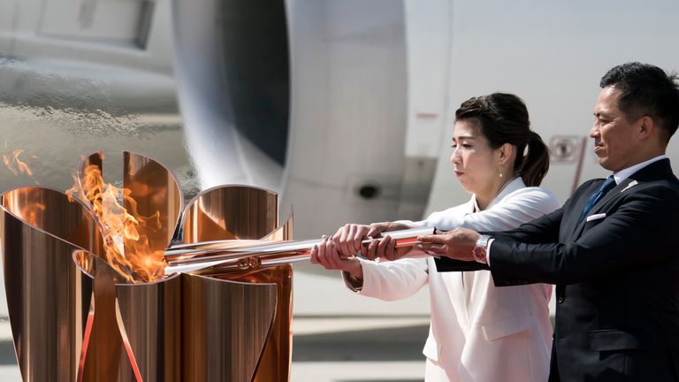 Olympic gold medallists Tadahiro Nomura (R) and Saori Yoshida (L) light the Olympic flame during the Tokyo 2020 Olympic Games Torch Arrival Ceremony in Matsushima, Miyagi, Japan.