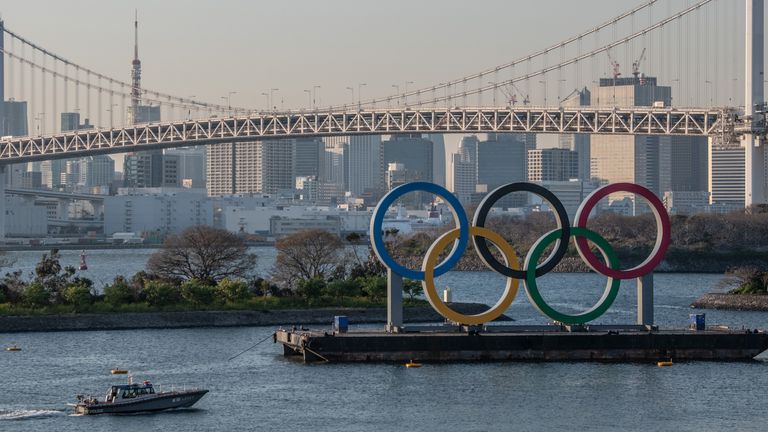 A police boat passes the Olympic Rings in Tokyo earlier this year