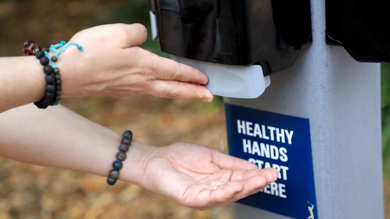 A spectator uses hand sanitizer during a practice round prior to The Players Championship at TPC Sawgrass