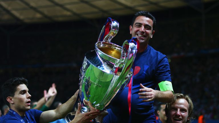 Xavi Hernandez of Barcelona celebrates with Ivan Rakitic (R) and the trophy after the UEFA Champions League Final between Juventus and FC Barcelona at Olympiastadion on June 6, 2015 in Berlin, Germany.