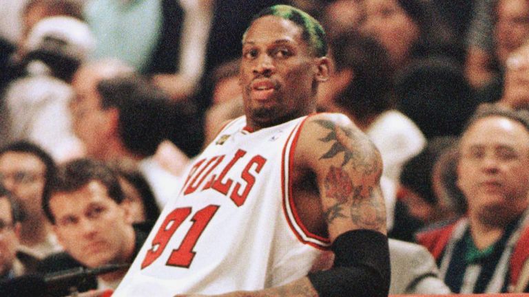 Dennis Rodman rests on the scorer's table during a Bulls game