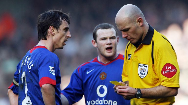 Neville has his name taken by Howard Webb during his time as United captain