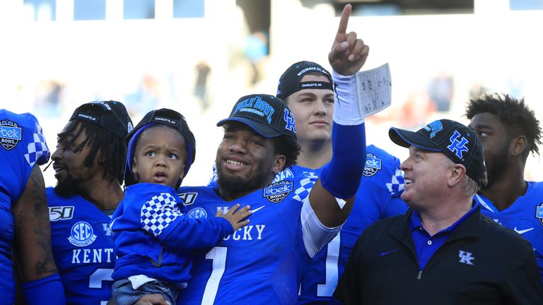 Lynn Bowden Jr. celebrates with his son and coach Stoops after the 2019 Belk Bowl against Virginia Tech