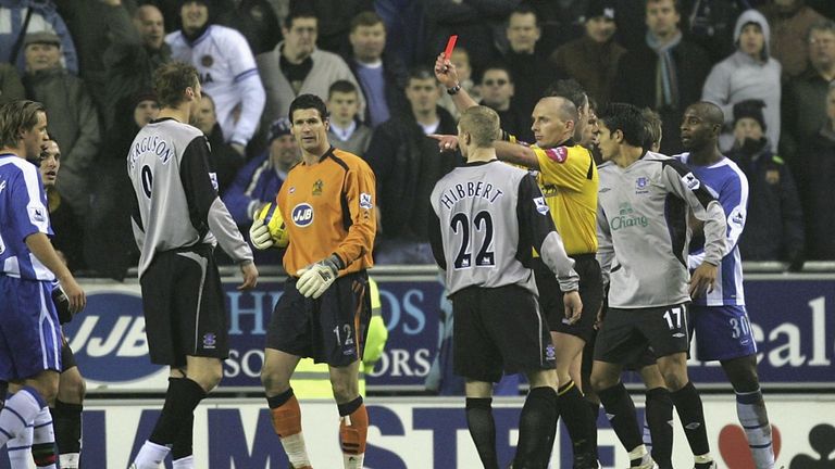 Referee Mike Dean brandishes the red card at Ferguson following a penalty-box melee