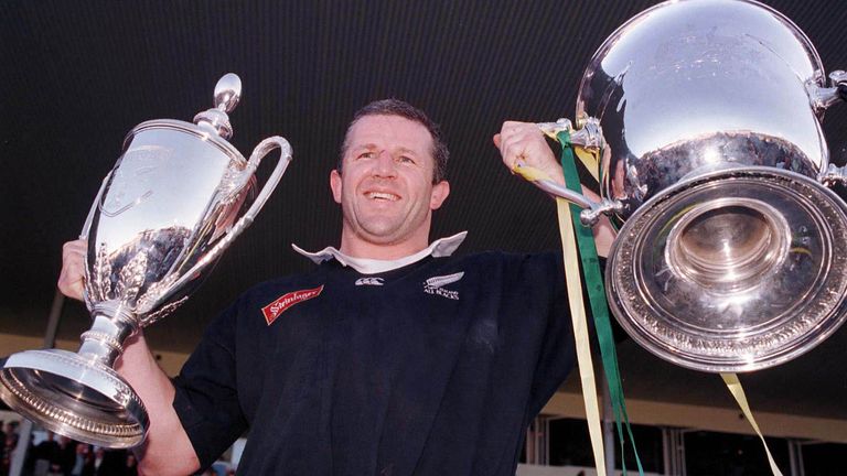 All Black Captain Sean Fitzpatrick holds aloft the Bledisloe Cup (right) and the Tri Nations trophy in 2005