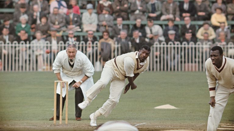 ANUARY 12: West Indies fast bowler Charlie Griffith in action as umpire Syd Buller and Wes Hall (r) look on during a tour match of England circa May 1966 in England, United Kingdom. 