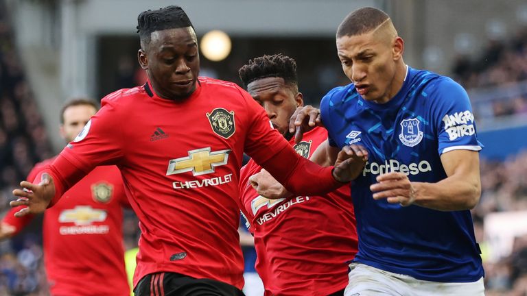 Richarlison of Everton is challenged by Fred and Aaron Wan Bissaka of Manchester United during the Premier League match between Everton FC and Manchester United at Goodison Park on March 01, 2020