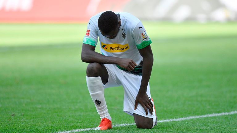 Marcus Thuram kneels after scoring against Union Berlin