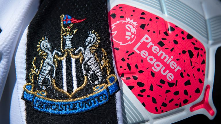 The Newcastle United club crest on the first team home shirt displayed with a Premier League match ball  