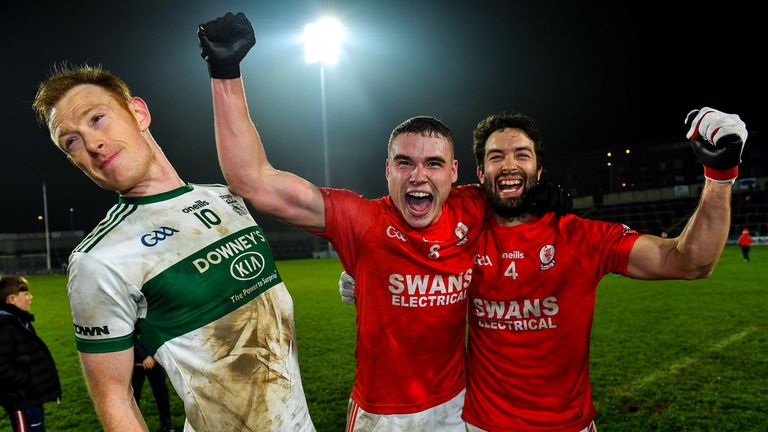 Éire Óg players Jordan Morrissey and Brendan Kavanagh celebrate their Leinster Club Championship victory, as Brian Glynn of Portlaoise attempts to make his way out of the shot