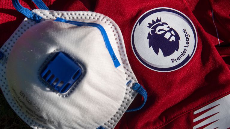 The Premier League logo on the sleeve of a shirt with a coronavirus protective face mask