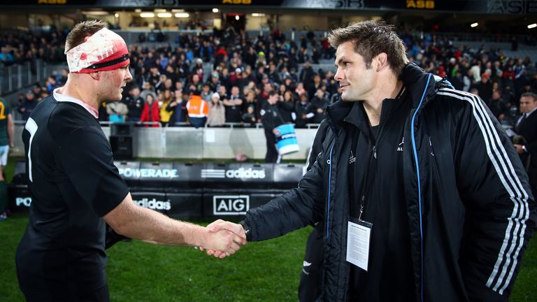 Sam Cane (L) shakes hands with Richie McCaw