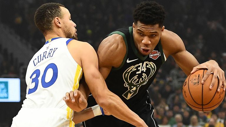 Stephen Curry tries to defend against Giannis Antetokounmpo
