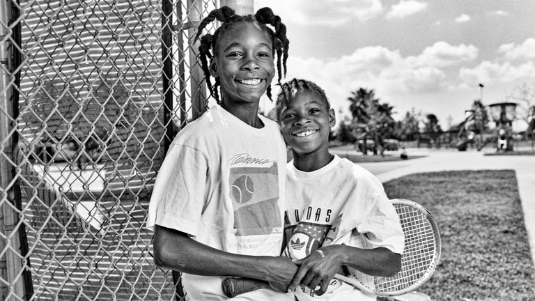 Portrait of American tennis players and sisters Venus Williams (left), 11, and Serena Williams, 9, as they pose beside the fence at the Compton tennis courts, South Central Los Angeles, California, April 20 1991. They had just complete a training session with their father and coach, Richard Williams. 