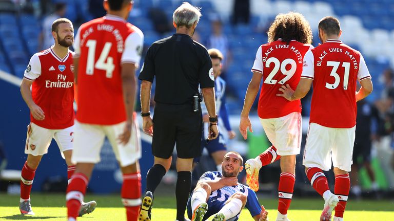 Brighton's Neal Maupay goes down clutching his throat after a clash with Arsenal's Matteo Guendouzi