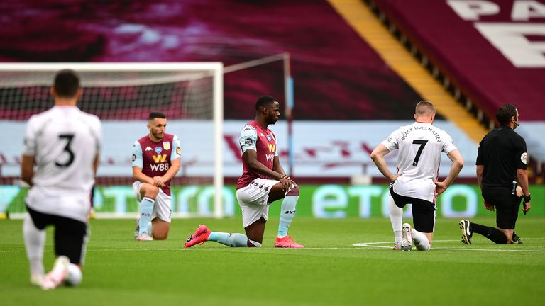 Keinan Davis of Aston Villa and John Lundstram of Sheffield United take a knee in support of the Black Lives Matter movement prior to the Premier League match between Aston Villa and Sheffield United at Villa Park on June 17, 2020 in Birmingham, England.