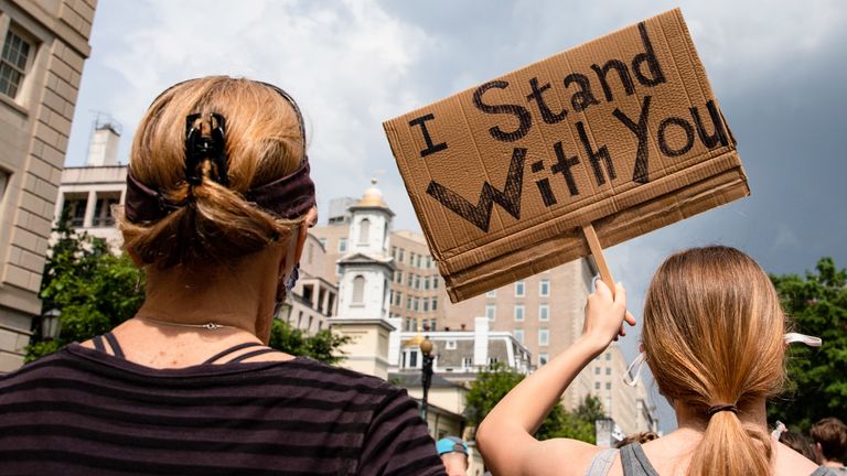 Protesters walk with signs near the White House during George Floyd protests on June 6 in Washington DC