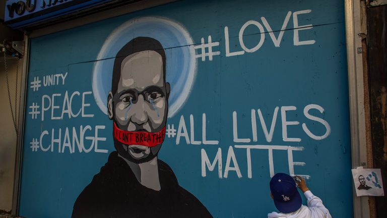 The artist Celos paints a mural in Downtown Los Angeles in protest against the death of George Floyd