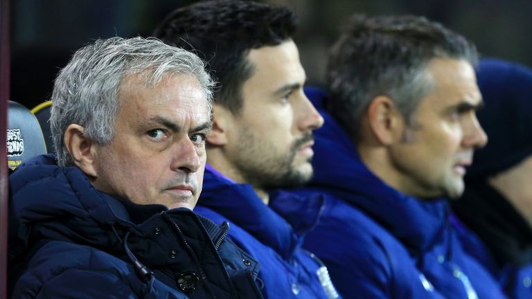 Jose Mourinho looks on alongside his coaching staff before a Premier League match