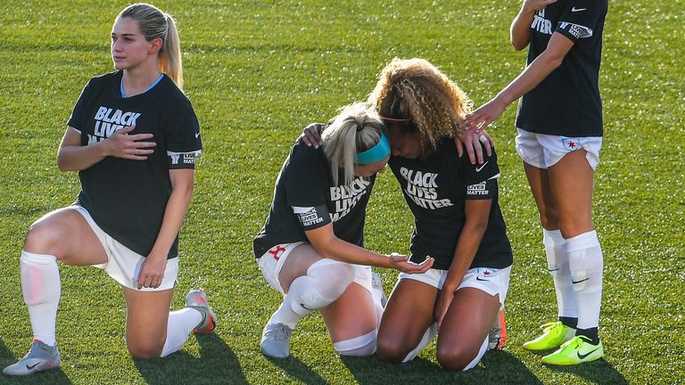 Julie Ertz consoles Red Stars teammate Casey Short as the pair take a knee during the US national anthem