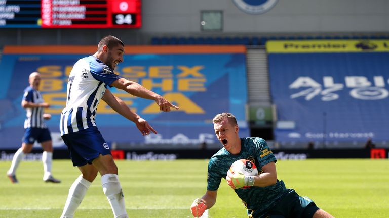 Bernd Leno of Arsenal attempts to collect the ball as he collides with Neal Maupay of Brighton and Hove Albion and later goes down injured during the Premier League match between Brighton & Hove Albion and Arsenal FC at American Express Community Stadium on June 20, 2020 in Brighton