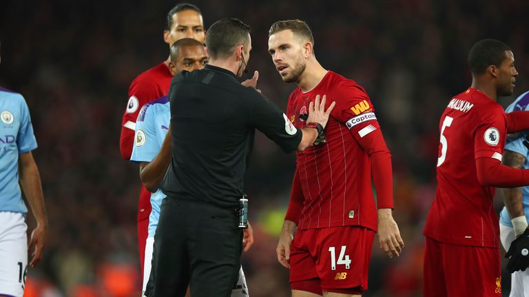 Michael Oliver is surrounded at Anfield