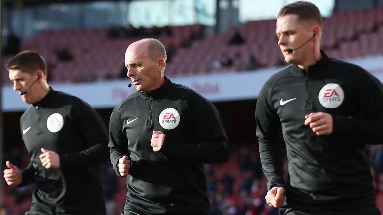 Mike Dean warms up at the Emirates Stadium