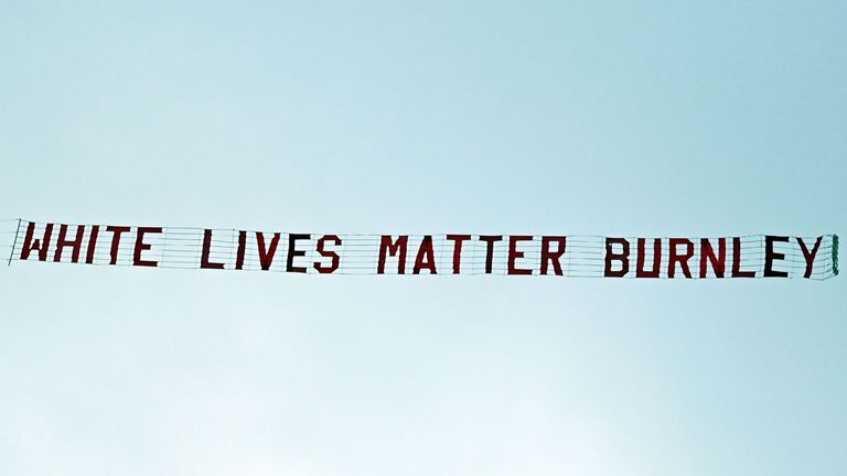 A banner reading 'White Lives Matter Burnley' is towed by a plane above the stadium during the English Premier League football match between Manchester City and Burnley at the Etihad Stadium in Manchester