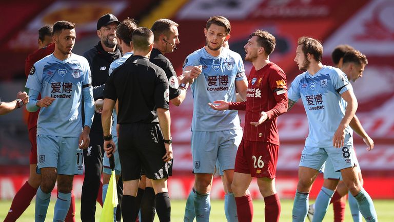Andy Robertson of Liverpool speaks with Match Referee, David Coote following the Premier League match between Liverpool FC and Burnley FC at Anfield on July 11, 2020 in Liverpool, England. Football Stadiums around Europe remain empty due to the Coronavirus Pandemic as Government social distancing laws prohibit fans inside venues resulting in all fixtures being played behind closed doors
