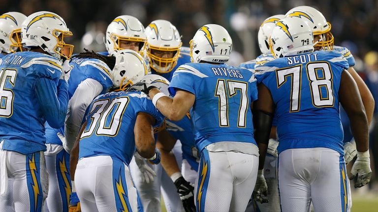 Chargers players in a huddle