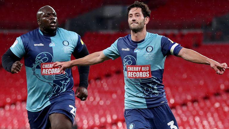 Adebayo Akinfenwa and Joe Jacobson celebrate the latter's penalty against Oxford United