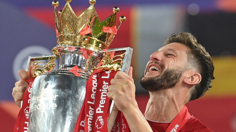Adam Lallana holding the Premier League trophy aloft after Liverpool's first top-flight title win in 30 years