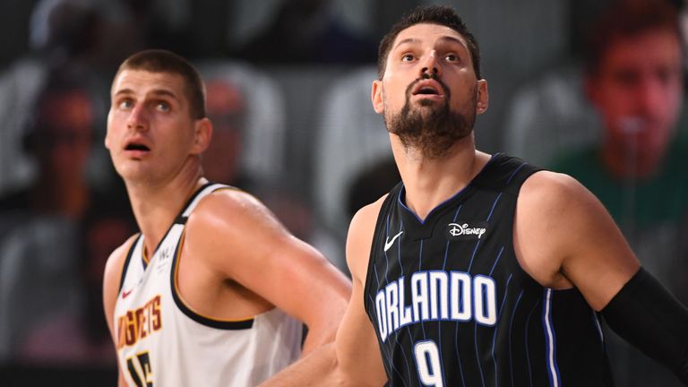 Nikola Jokic and Nikola Vucevic compete for a rebound