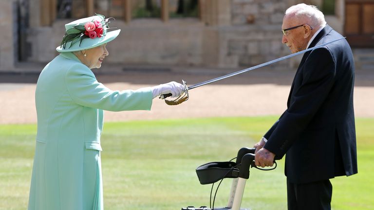 Queen Elizabeth II awards Captain Sir Thomas Moore with the insignia of Knight Bachelor at Windsor Castle on July 17, 2020 in Windsor, England.