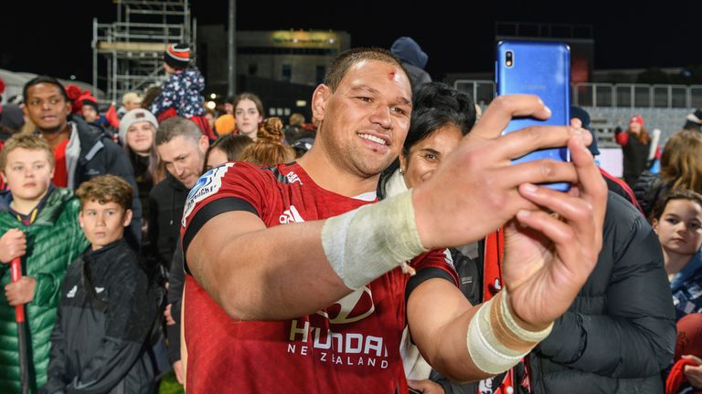 The Crusaders' Whetukamokamo Douglas poses for selfies with fans after their win over the Blues