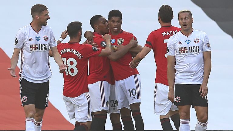Sheffield United's Chris Basham and Phil Jagielka look dejected as Manchester United celebrate