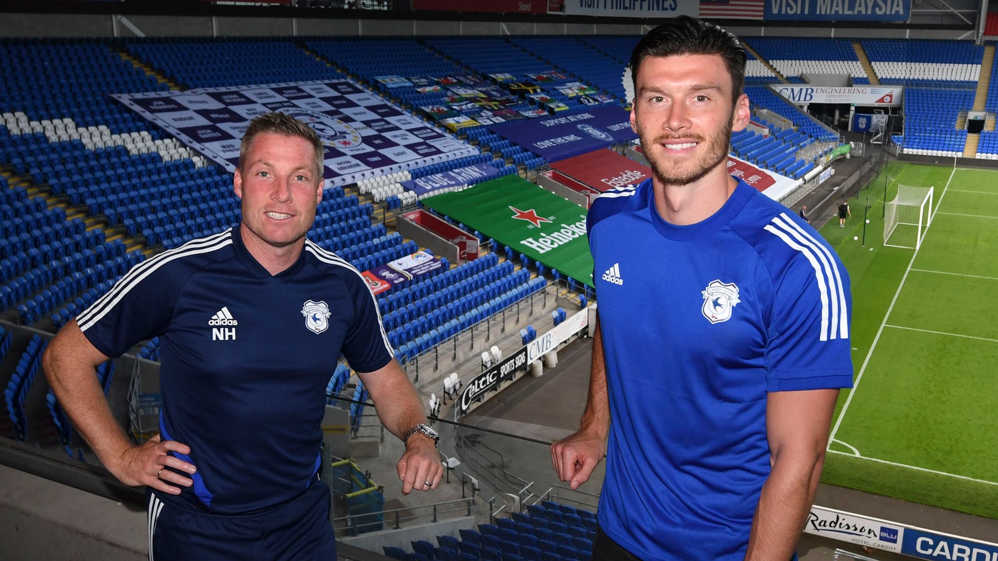 Moore pictured with Cardiff boss Neil Harris after completing his move.