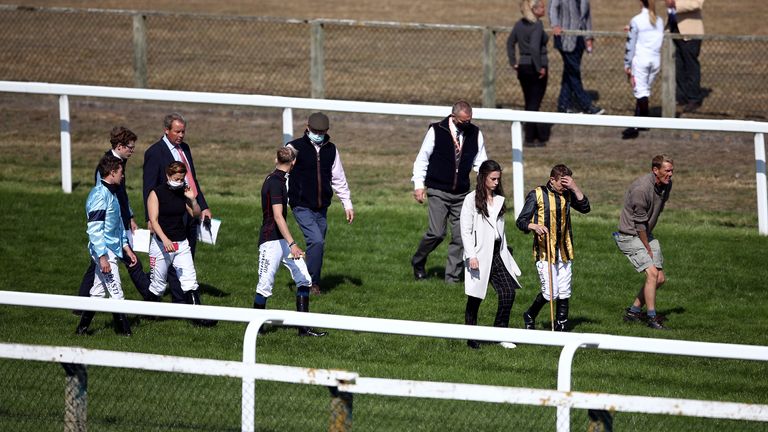 The ground is inspected after a fall in the Sky Sports Racing Sky 415 Handicap at Great Yarmouth Racecourse.