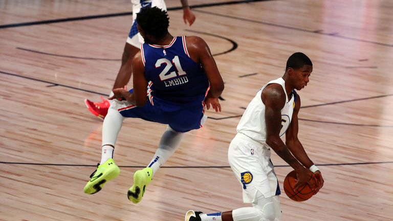 Joel Embiid takes a heavy fall after chasing a wayward pass from team-mate Shake Milton