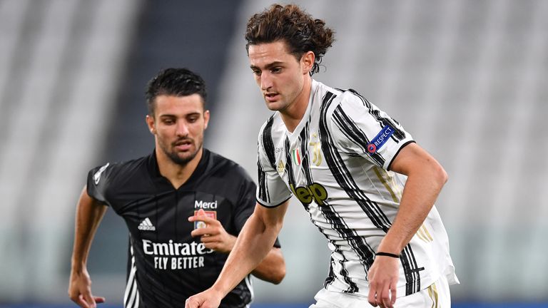 Juventus' Adrien Rabiot runs with the ball under pressure from Lyon's Leo Dubois