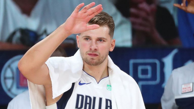 Luka Doncic high-fives his team-mates following the Mavericks&#39; Game 2 win over the Clippers