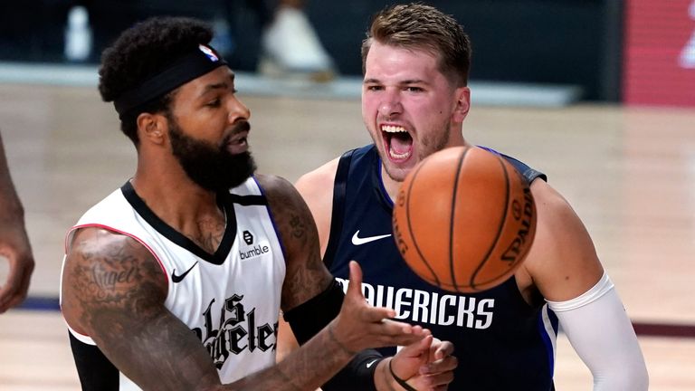 Luka Doncic of the Dallas Mavericks reacts after making a basket as LA Clippers&#39; Marcus Morris Sr reaches for the ball