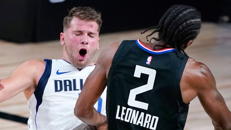 Luka Doncic takes a charge from Kawhi Leonard