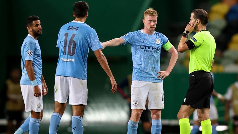 Man City players wait for a VAR check to take place to see if Lyon's second goal will stand 