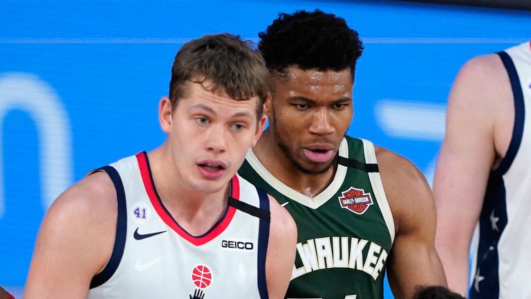 Mo Wagner and Giannis Antetokounmpo are reprimanded by the referee
