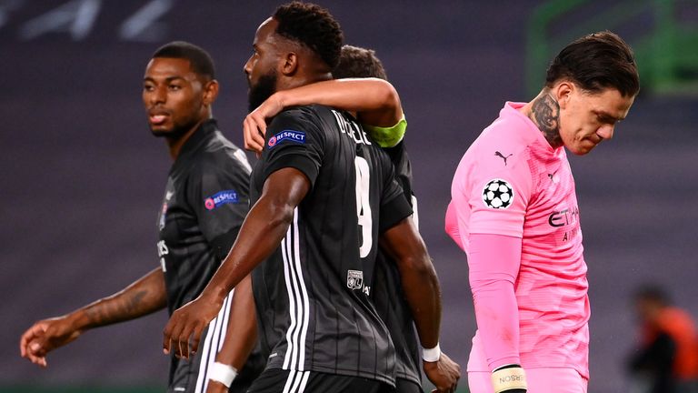 Moussa Dembele celebrates scoring for Lyon as Manchester City goalkeeper Ederson looks on