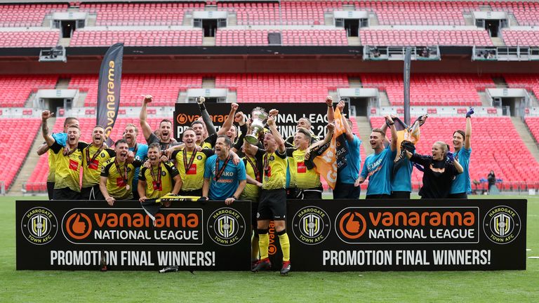 Harrogate Town players and staff celebrate with National League play-off final trophy at Wembley after beating Notts County 3-1
