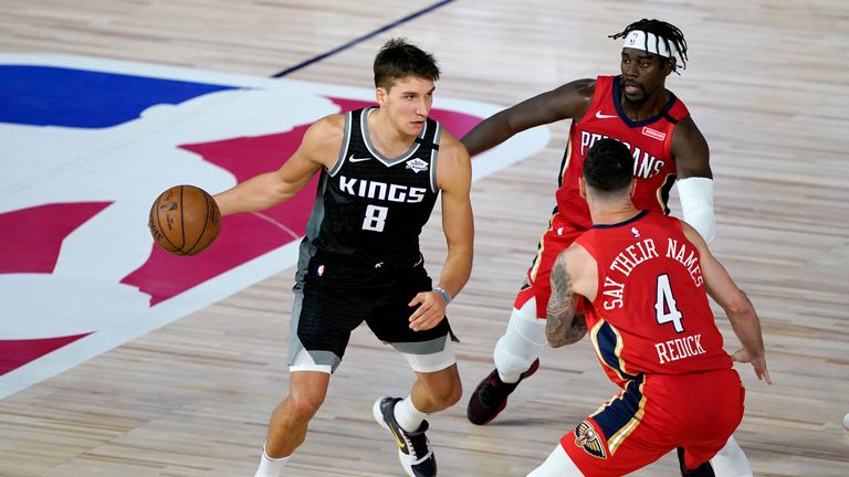 Bogdan Bogdanovic #8 of the Sacramento Kings drives against Jrue Holiday, back right, and JJ Redick #4 of the New Orleans Pelicans during the second half of an NBA basketball game at HP Field House at ESPN Wide World Of Sports Complex on August 6, 2020 in Lake Buena Vista, Florida.