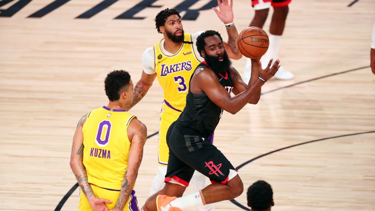 James Harden #13 of the Houston Rockets passes the ball against Kyle Kuzma #0 and Anthony Davis #3 of the Los Angeles Lakers in the second half at The Arena at ESPN Wide World Of Sports Complex on August 6, 2020 in Lake Buena Vista, Florida.